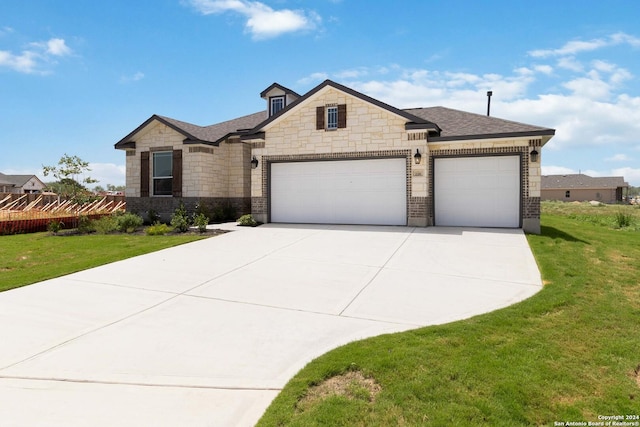 view of front of property with a garage and a front lawn