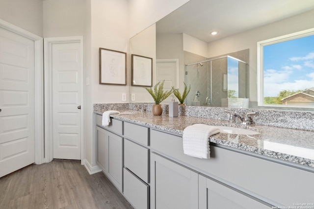 bathroom featuring vanity, wood-type flooring, and a shower with door