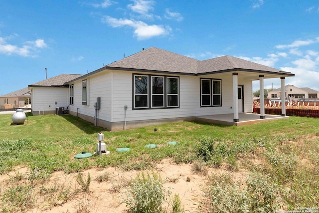 back of property with a lawn, a patio area, and central AC unit