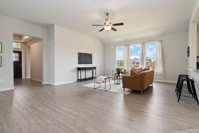 living room with a fireplace, wood-type flooring, and ceiling fan