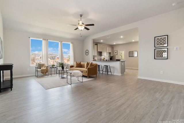 living room with light hardwood / wood-style flooring and ceiling fan