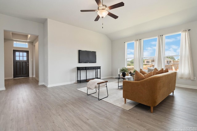 living room featuring wood-type flooring, vaulted ceiling, ceiling fan, and a healthy amount of sunlight