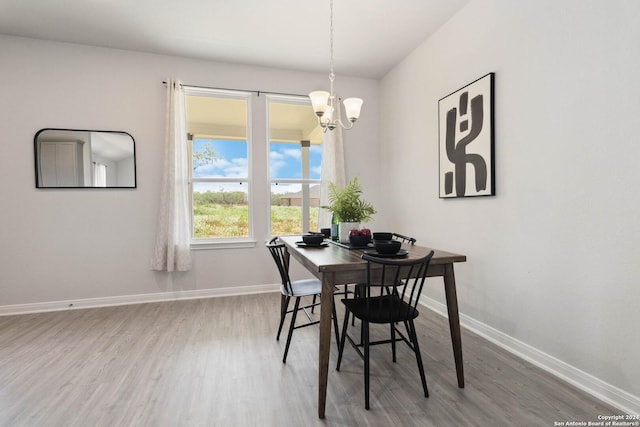 dining area with a chandelier and wood-type flooring