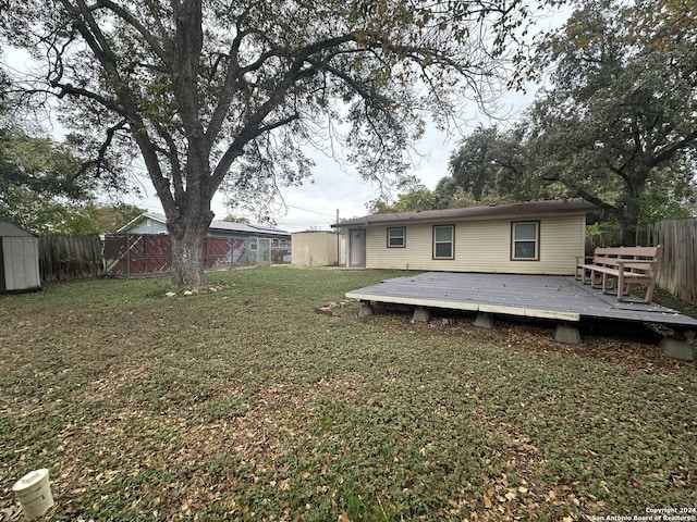 view of yard with a wooden deck and a storage unit