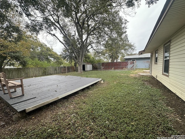 view of yard with a deck and a storage unit