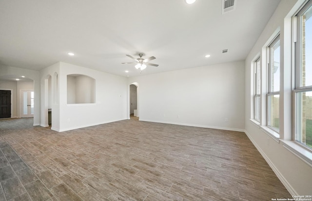 unfurnished living room featuring dark hardwood / wood-style floors and ceiling fan