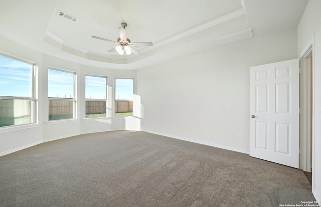 carpeted spare room with a raised ceiling, ceiling fan, and crown molding