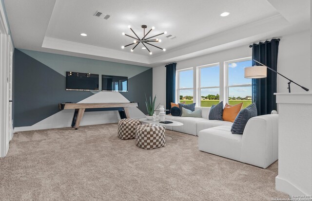 carpeted living room featuring a tray ceiling, a chandelier, and ornamental molding