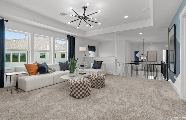 living room with light colored carpet, crown molding, a tray ceiling, and an inviting chandelier