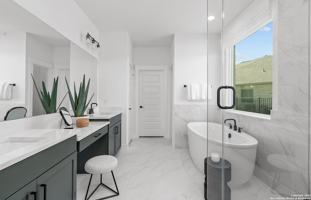 bathroom featuring a washtub, vanity, and tile walls