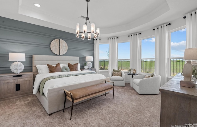 bedroom with light carpet, a raised ceiling, and multiple windows