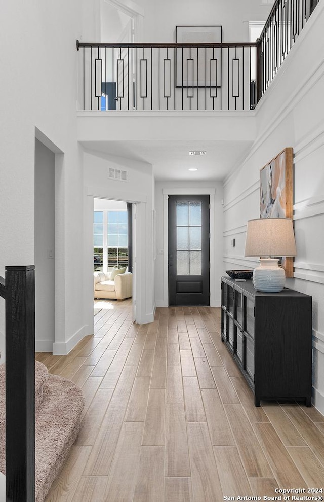 foyer with a high ceiling and light hardwood / wood-style floors