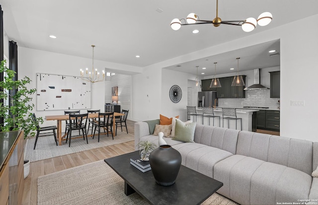 living room with a chandelier, sink, and light hardwood / wood-style flooring