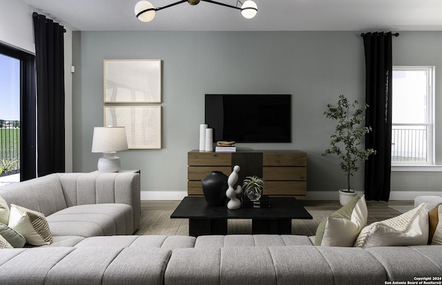 living room featuring light hardwood / wood-style floors, an inviting chandelier, and a wealth of natural light