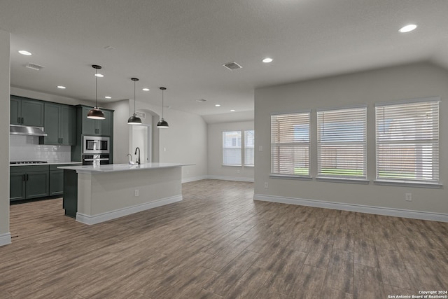 kitchen featuring pendant lighting, a center island with sink, sink, dark hardwood / wood-style flooring, and stainless steel appliances