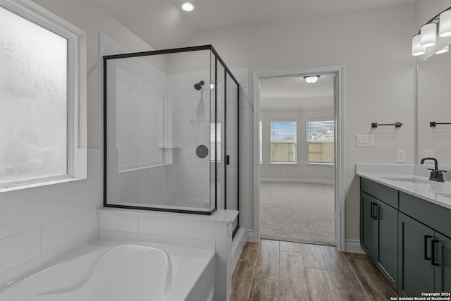 bathroom featuring vanity, wood-type flooring, and shower with separate bathtub