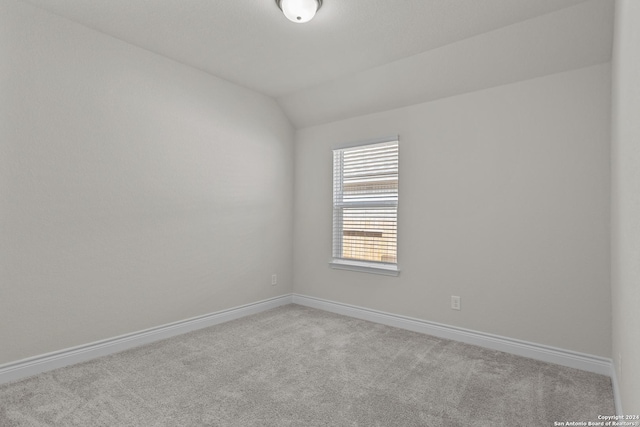 empty room with light carpet and vaulted ceiling