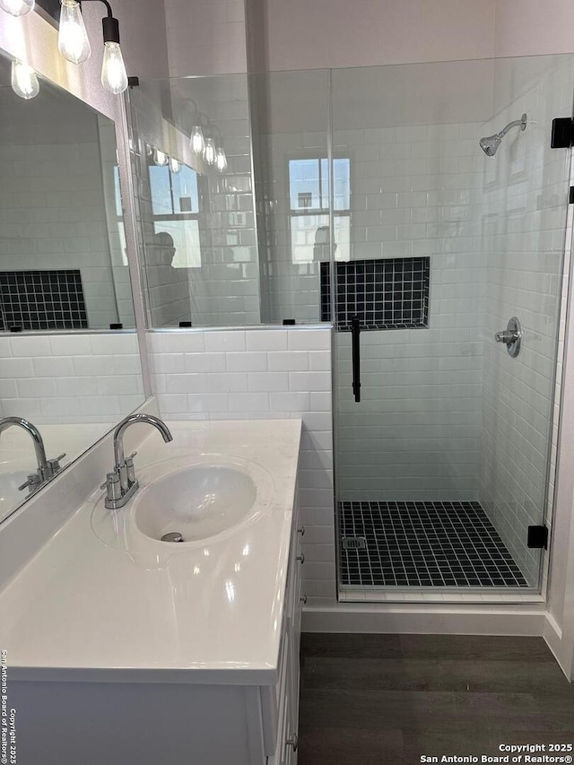 bathroom with an enclosed shower, vanity, and wood-type flooring