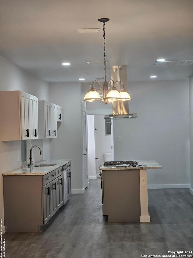 kitchen featuring sink, light stone counters, a notable chandelier, and hanging light fixtures