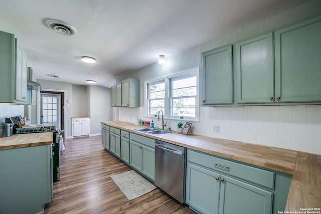 kitchen with stainless steel dishwasher, gas range oven, sink, butcher block countertops, and dark hardwood / wood-style floors