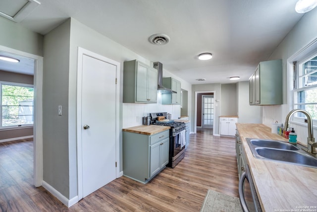 kitchen featuring sink, dark hardwood / wood-style floors, butcher block counters, and stainless steel gas range