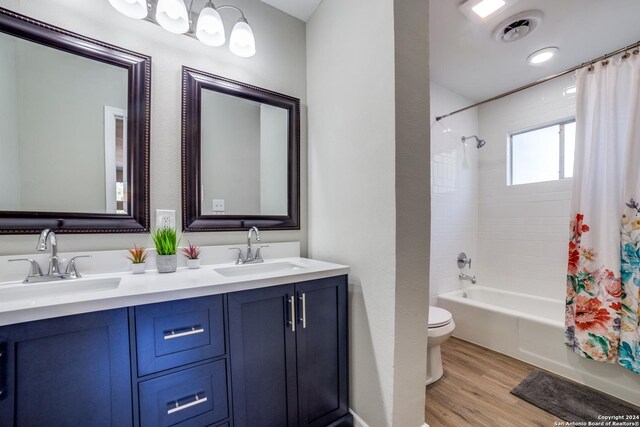 full bathroom with vanity, wood-type flooring, shower / tub combo, and toilet