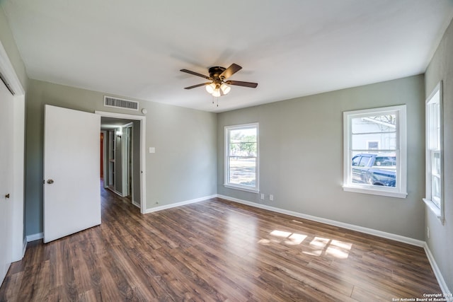 empty room with ceiling fan and dark wood-type flooring