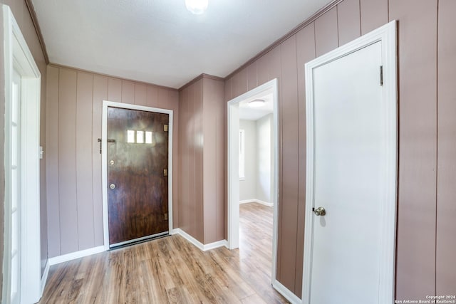 entryway with crown molding and light hardwood / wood-style flooring