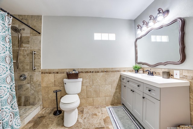 bathroom featuring walk in shower, vanity, toilet, and tile walls