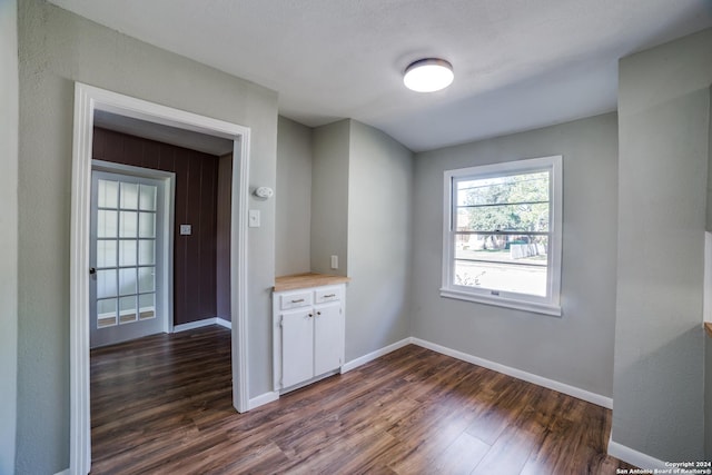 unfurnished room with dark hardwood / wood-style flooring