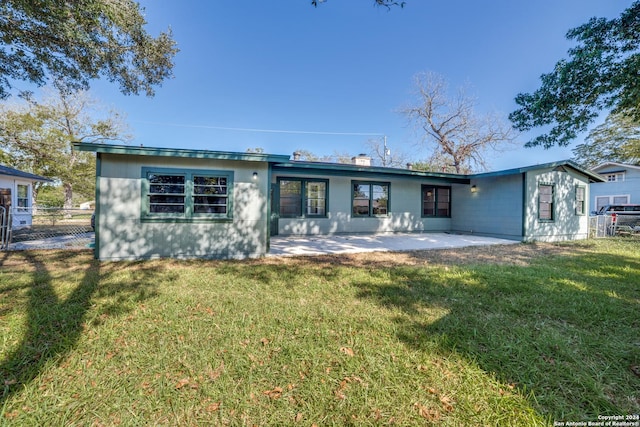 rear view of property with a patio and a lawn