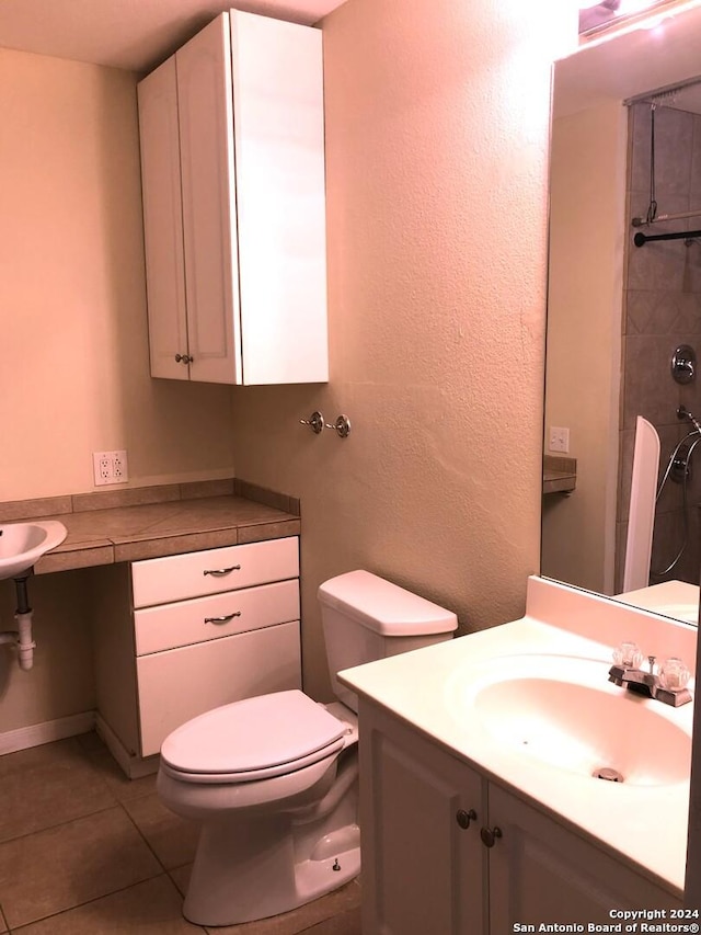 bathroom with tile patterned flooring, vanity, and toilet