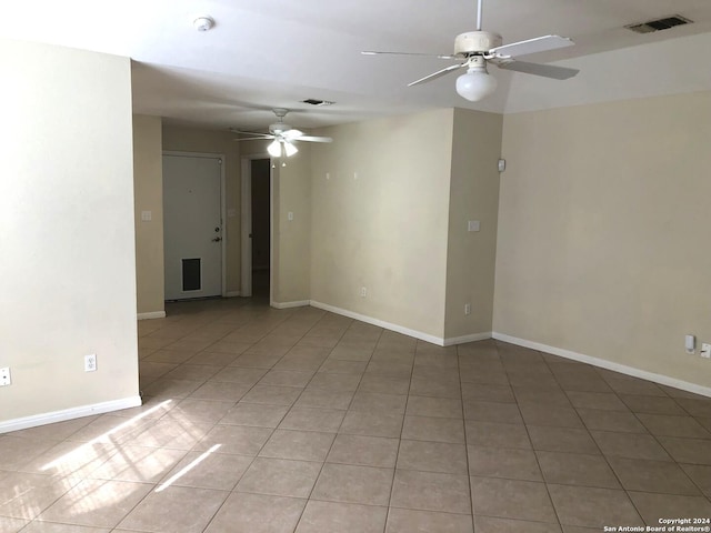 empty room with ceiling fan and light tile patterned floors