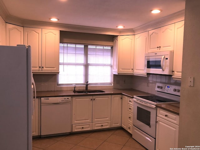 kitchen featuring sink, white cabinets, and white appliances