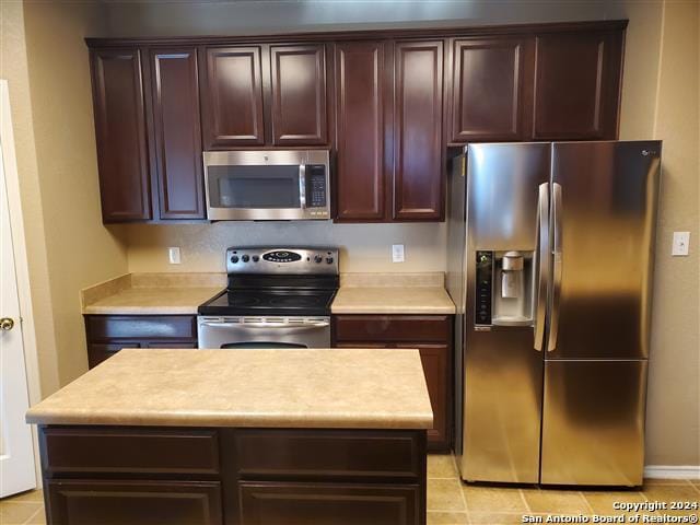 kitchen featuring appliances with stainless steel finishes, a center island, and light tile patterned floors