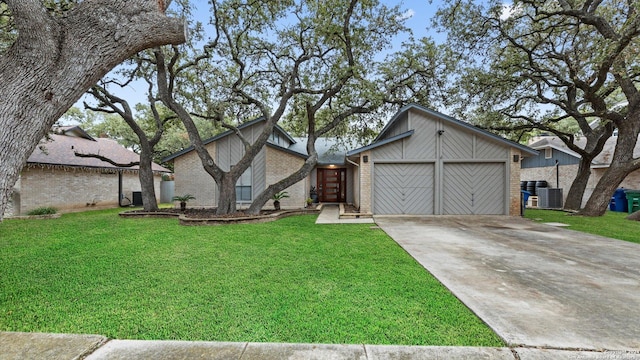 view of front of property with central AC unit, a garage, and a front lawn