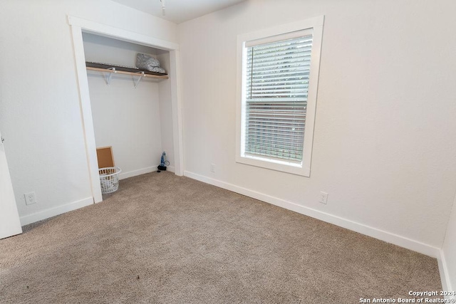 unfurnished bedroom featuring carpet and a closet