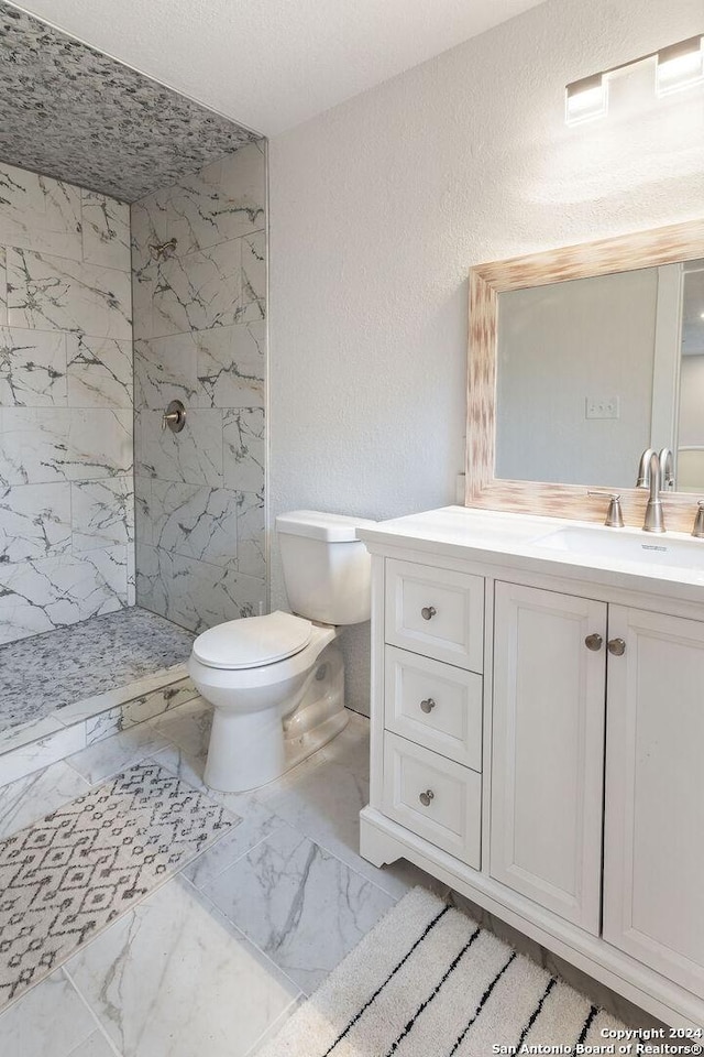 bathroom featuring tiled shower, vanity, a textured ceiling, and toilet