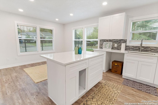 kitchen featuring a wealth of natural light, sink, and white cabinets