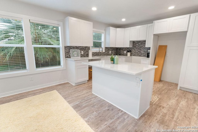 kitchen featuring a center island, a healthy amount of sunlight, and white cabinetry