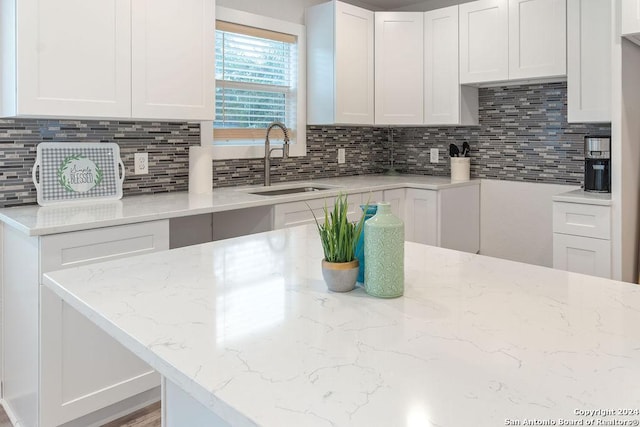 kitchen with white cabinets, backsplash, and sink