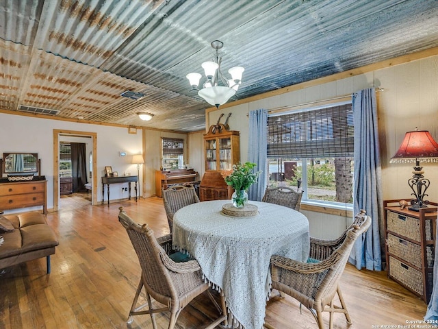 dining space with a notable chandelier and light hardwood / wood-style floors