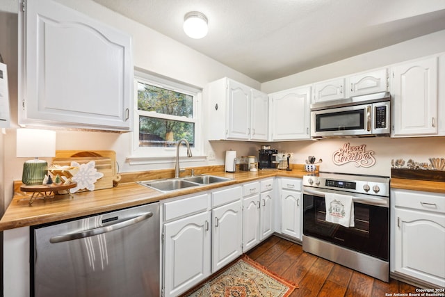 kitchen featuring butcher block counters, sink, white cabinets, and stainless steel appliances