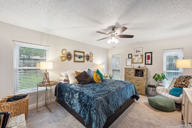 bedroom with light carpet, a textured ceiling, and ceiling fan