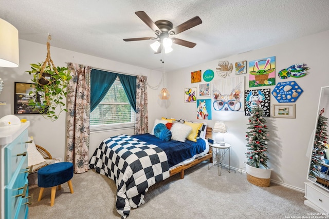 carpeted bedroom featuring ceiling fan and a textured ceiling