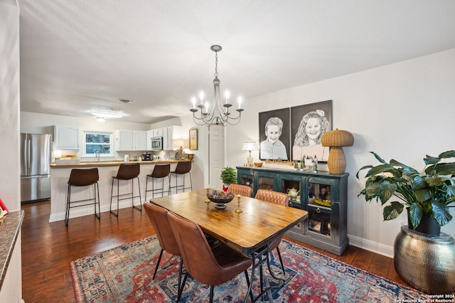 dining area with dark hardwood / wood-style flooring, sink, and a chandelier