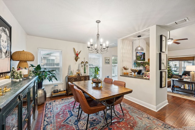 dining space with dark hardwood / wood-style flooring, a healthy amount of sunlight, and ceiling fan with notable chandelier