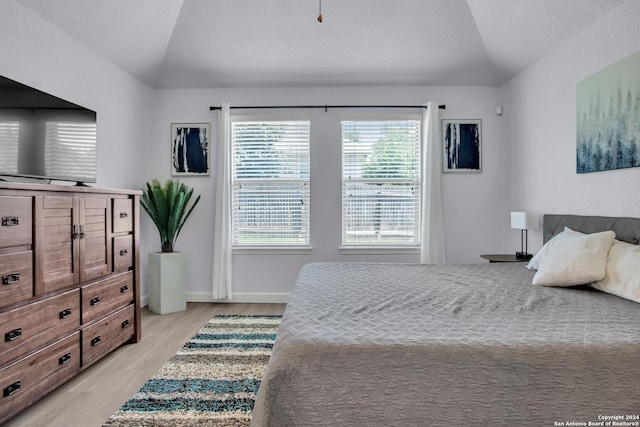 bedroom featuring light hardwood / wood-style floors and vaulted ceiling