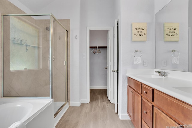 bathroom with separate shower and tub, vanity, and hardwood / wood-style flooring