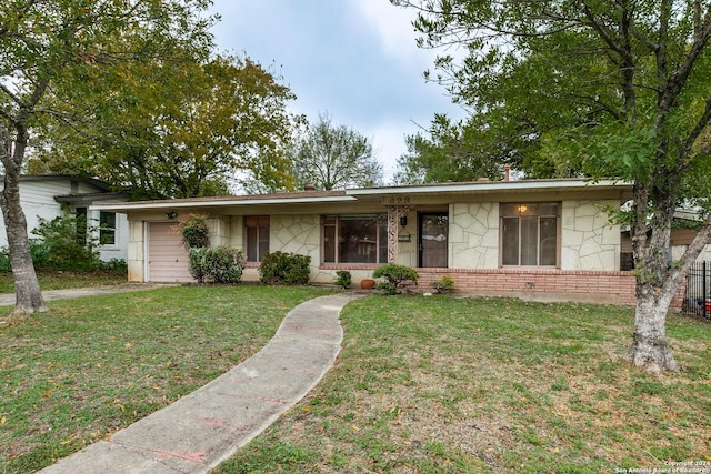 single story home featuring a garage and a front lawn